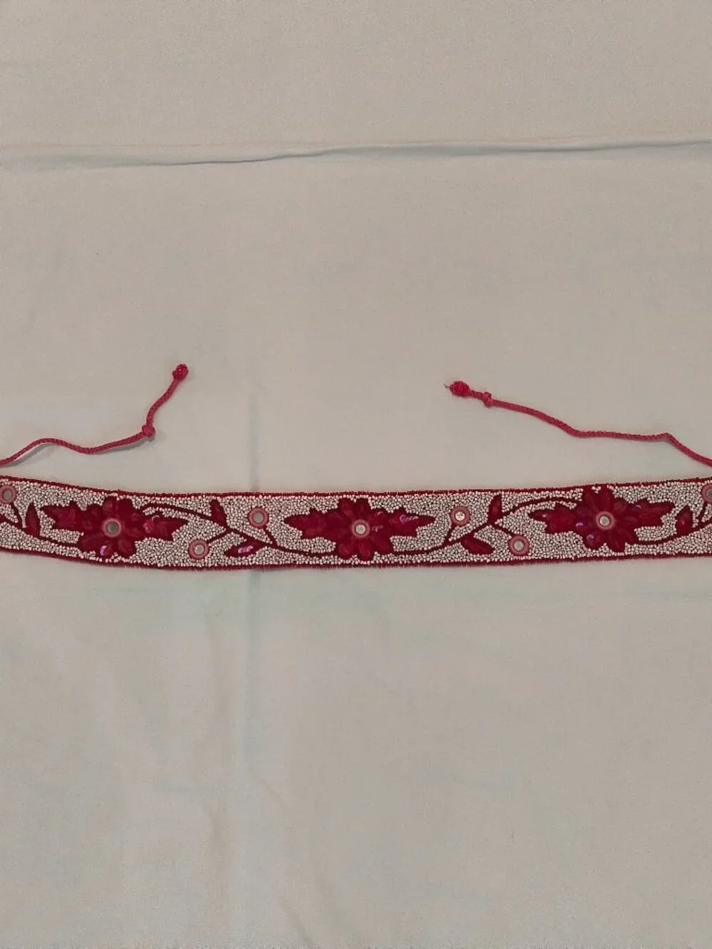red beaded belt with a floral design